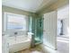 Stylish bathroom with a soaking tub, glass shower, tile accents, and natural light from a window at 1723 E Behrend Dr, Phoenix, AZ 85024