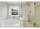 Bright bathroom with white cabinets, large tub, and glass shower at 1723 E Behrend Dr, Phoenix, AZ 85024