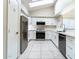 Modern kitchen featuring white cabinets, stainless steel appliances, tile backsplash, and a skylight for natural light at 1723 E Behrend Dr, Phoenix, AZ 85024