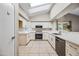 Bright kitchen with white cabinets, stainless appliances, and skylight at 1723 E Behrend Dr, Phoenix, AZ 85024