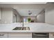 Bright kitchen sink with white quartz countertops, stainless steel fixtures and views of the living room at 1723 E Behrend Dr, Phoenix, AZ 85024