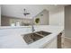 Bright kitchen sink with white quartz countertops, stainless steel fixtures and views of the living room at 1723 E Behrend Dr, Phoenix, AZ 85024