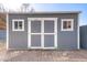 Exterior shot of storage shed with double doors and natural light coming in from two windows at 1723 E Behrend Dr, Phoenix, AZ 85024