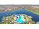 Aerial view of the community pool area, lake, and palm trees, creating a resort-like atmosphere at 17878 W Amber Ridge Way, Goodyear, AZ 85338