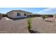 Gravel backyard view showcases the patio, outdoor kitchen, and fruit trees at 17878 W Amber Ridge Way, Goodyear, AZ 85338