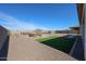 Expansive backyard featuring gravel ground, a patch of grass, and an outdoor seating area at 17878 W Amber Ridge Way, Goodyear, AZ 85338