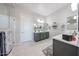 Bathroom featuring a large mirror, double sinks, gray cabinets, and a glass enclosed shower at 17878 W Amber Ridge Way, Goodyear, AZ 85338