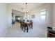 Dining room adjacent to the kitchen with a wood table, six chairs, and modern lighting at 17878 W Amber Ridge Way, Goodyear, AZ 85338