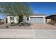 Charming single-story home with desert landscaping, a brick driveway, and a gray garage door at 17878 W Amber Ridge Way, Goodyear, AZ 85338