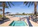 A built-in hot tub near the community pool, framed by lush greenery and lounge chairs at 17878 W Amber Ridge Way, Goodyear, AZ 85338