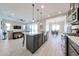 Bright open kitchen featuring a kitchen island with sink, stainless steel appliances, and gray cabinets at 17878 W Amber Ridge Way, Goodyear, AZ 85338