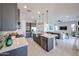 Modern open concept kitchen with stainless steel appliances, kitchen island with seating, and gray cabinets at 17878 W Amber Ridge Way, Goodyear, AZ 85338