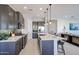 Modern kitchen with stainless steel appliances, gray cabinets, kitchen island and green tile backsplash at 17878 W Amber Ridge Way, Goodyear, AZ 85338