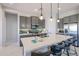 Modern kitchen with gray cabinets, stainless steel appliances, and a large quartz countertop island with seating at 17878 W Amber Ridge Way, Goodyear, AZ 85338