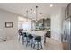 Stylish kitchen with an island and bar stool seating, gray cabinets, and stainless steel appliances at 17878 W Amber Ridge Way, Goodyear, AZ 85338