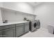 Bright laundry room featuring modern appliances, storage cabinets, and ample counter space at 17878 W Amber Ridge Way, Goodyear, AZ 85338