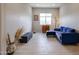 Modern living room with tile flooring, a gray bench, and a comfy blue sectional sofa at 17878 W Amber Ridge Way, Goodyear, AZ 85338