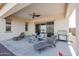 Stylish outdoor living area with lounge chairs, a ceiling fan, a BBQ grill, and desert landscaping at 17878 W Amber Ridge Way, Goodyear, AZ 85338