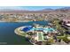 Aerial view of the community pool, lake, shuffleboard court, and palm trees, creating a relaxing oasis at 17878 W Amber Ridge Way, Goodyear, AZ 85338