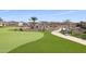 Community putting green bordered by rocks, desert foliage and a comfortable bench at 17878 W Amber Ridge Way, Goodyear, AZ 85338