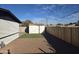 Wide view of a fenced-in backyard featuring a shed, small artificial grass lawn, gravel, and a secure perimeter at 1835 E Atlanta Ave, Phoenix, AZ 85040