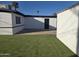 Backyard view with a patch of artificial grass, palm tree, and a fenced exterior, offering a relaxing outdoor space at 1835 E Atlanta Ave, Phoenix, AZ 85040