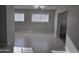 Living room with tile flooring, a modern light fixture, and natural light from two windows at 1835 E Atlanta Ave, Phoenix, AZ 85040