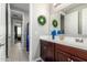 Bathroom featuring a wooden vanity, a large mirror, and view of a hallway at 19806 W San Miguel Ave, Litchfield Park, AZ 85340