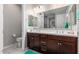 Bright bathroom with dual sinks, dark wood cabinets, white countertops, and a large mirror at 19806 W San Miguel Ave, Litchfield Park, AZ 85340