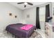 Bedroom featuring white tile floors, a ceiling fan, a purple comforter, and dark curtains at 19806 W San Miguel Ave, Litchfield Park, AZ 85340