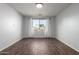 Bright bedroom features wood-look tile flooring, neutral paint, and a window with backyard views at 19982 W Glenrosa Ave, Litchfield Park, AZ 85340