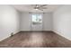 Bright bedroom features wood-look tile flooring, neutral paint, a ceiling fan, and a window with backyard views at 19982 W Glenrosa Ave, Litchfield Park, AZ 85340