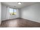 Bright bedroom features wood-look tile flooring, neutral paint, and a window with backyard views at 19982 W Glenrosa Ave, Litchfield Park, AZ 85340