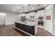 Modern kitchen with black island, stainless steel appliances, white cabinets, and pendant lighting at 19982 W Glenrosa Ave, Litchfield Park, AZ 85340