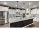 Bright kitchen featuring white cabinets, stainless steel appliances, a large island, and pendant lighting at 19982 W Glenrosa Ave, Litchfield Park, AZ 85340