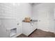 Bright laundry room with white subway tile, shaker cabinets, and wood-look tile flooring at 19982 W Glenrosa Ave, Litchfield Park, AZ 85340