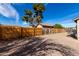 Large backyard featuring a wooden fence, gravel landscaping, and mature trees at 200 E Hess Ave, Coolidge, AZ 85128