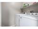 Modern laundry room featuring white, front-load washer and dryer set with overhead storage shelf at 200 E Hess Ave, Coolidge, AZ 85128