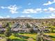 Expansive aerial view of a well-planned community featuring lush green spaces, mature trees, and beautiful mountain views at 20391 N Sunrise Ln, Maricopa, AZ 85138