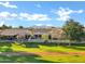 An aerial view showcases a home with a lush backyard and mature trees, bordering a well-manicured green space at 20391 N Sunrise Ln, Maricopa, AZ 85138