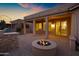 Inviting back patio featuring a cozy fire pit, outdoor kitchen with grill, and covered seating area perfect for relaxation at 20391 N Sunrise Ln, Maricopa, AZ 85138