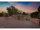 Outdoor grill and gas fire pit area against a beautiful sky at twilight at 20391 N Sunrise Ln, Maricopa, AZ 85138