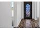 A modern front door with black wrought iron opens to a hallway with wood-look tile flooring at 20391 N Sunrise Ln, Maricopa, AZ 85138