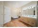 Full bathroom with a soaking tub, double sink vanity, and decorative tile accents at 2070 W Bromm Ln, Wickenburg, AZ 85390