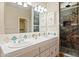 Bathroom featuring double sinks, tiled shower, and a large mirror at 2070 W Bromm Ln, Wickenburg, AZ 85390