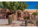 Close up of a home featuring a arched entryway and native desert landscaping at 2070 W Bromm Ln, Wickenburg, AZ 85390