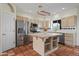 Full kitchen view with stainless appliances, white cabinets, island, and tiled floor at 2070 W Bromm Ln, Wickenburg, AZ 85390