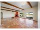 Spacious living room with tile floors, beamed ceilings, and a striking brick fireplace at 2070 W Bromm Ln, Wickenburg, AZ 85390