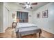 Neutral bedroom featuring a ceiling fan, a bedside table, and tiled floors at 214 N 222Nd Dr, Buckeye, AZ 85326