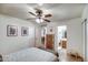 Calm bedroom with tiled floor and fan, and a glimpse into the en-suite bathroom at 214 N 222Nd Dr, Buckeye, AZ 85326